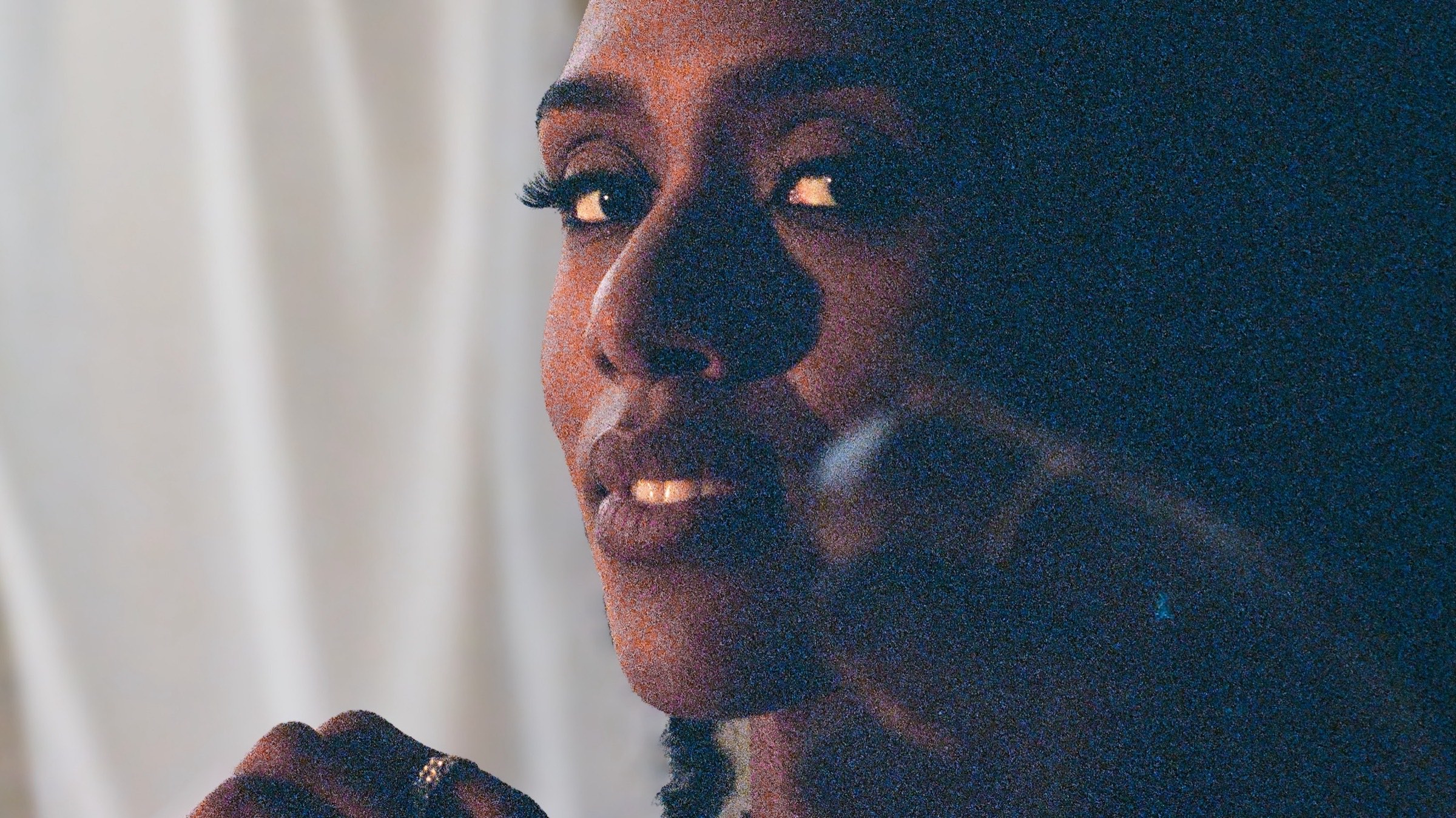 Alicia Waller singing close to the microphone, shot on grainy film in warm low light.